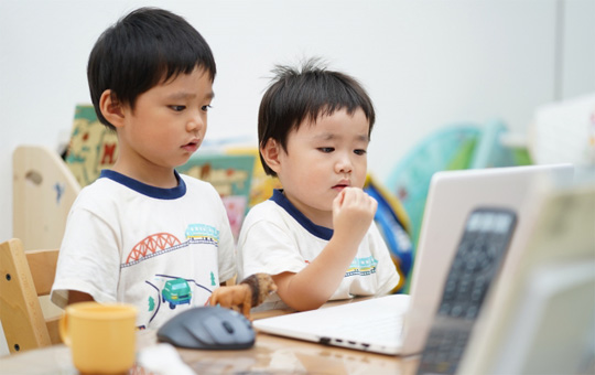 パソコンを見ている二人の男の子